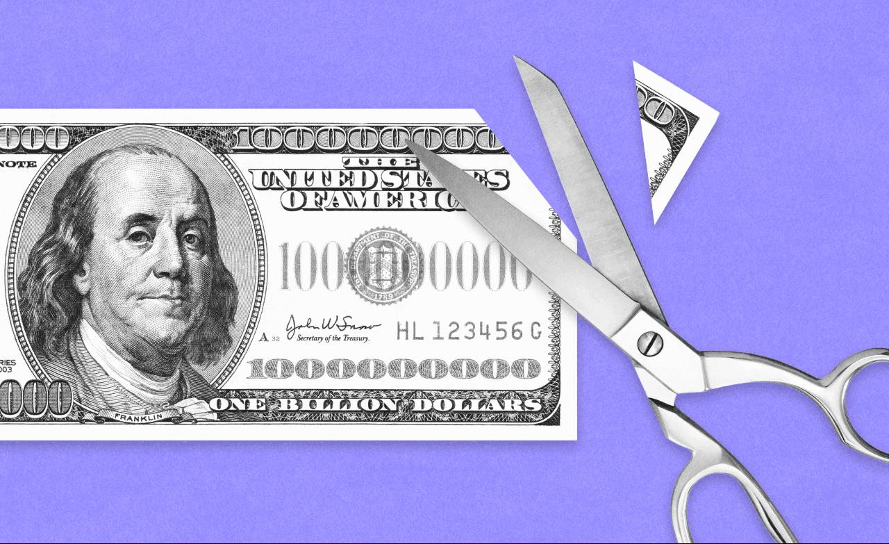 Scissors cutting a one-billion-dollar bill